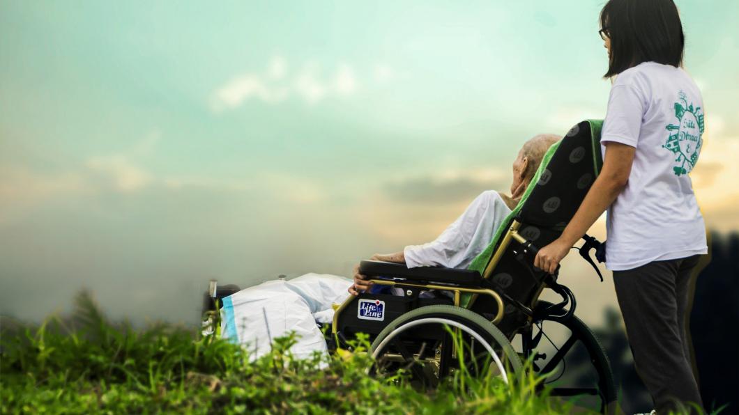 Jonge vrouw duwt rolstoel en kijken samen naar het uitzicht