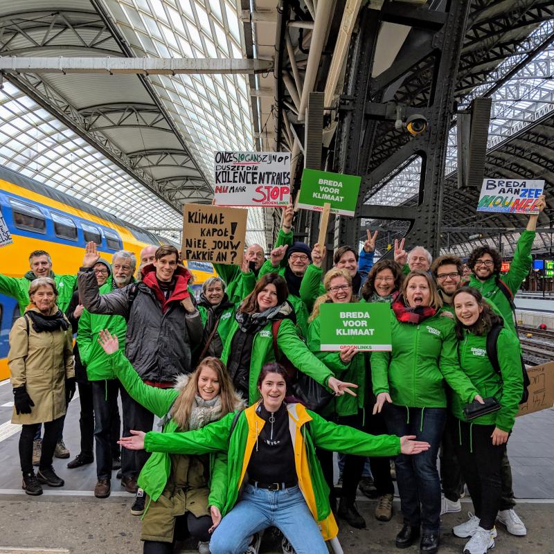Groep GroenLinksers met protestbordjes poserend voor de camera